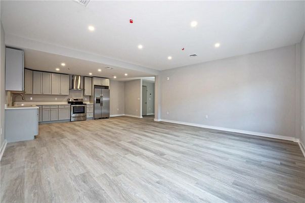 Empty room, Interior, Kitchen, Recessed Lighting, Stainless Steel Appliances, Wood Texture Flooring