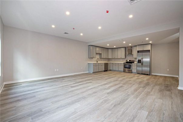 Empty room, Interior, Kitchen, Recessed Lighting, Stainless Steel Appliances, Wood Texture Flooring