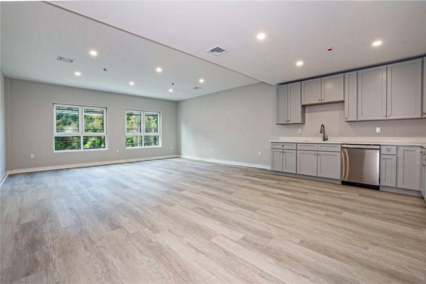 Empty room, Interior, Kitchen, Recessed Lighting, Stainless Steel Appliances, Wood Texture Flooring