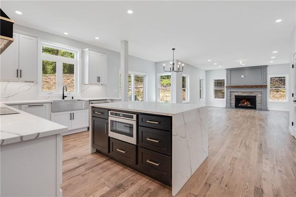 Fireplace, Interior, Kitchen, Marble Walls, Pendant Lights, Recessed Lighting, Stainless Steel Appliances, Wood Texture Flooring