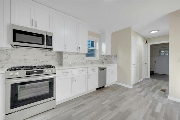 Interior, Kitchen, Marble Walls, Recessed Lighting, Stainless Steel Appliances, Wood Texture Flooring