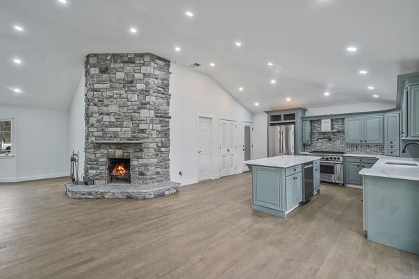 Fireplace, Interior, Kitchen, Recessed Lighting, Stainless Steel Appliances, Stone Walls, Wood Texture Flooring
