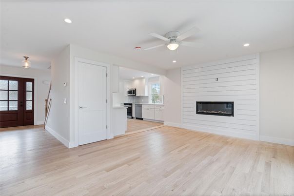 Empty room, Fireplace, Interior, Kitchen, Recessed Lighting, Stainless Steel Appliances, Wood Texture Flooring