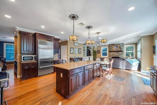 Chandelier, Dining room, Fireplace, Interior, Kitchen, Living room, Pendant Lights, Recessed Lighting, Stainless Steel Appliances, Stone Walls, Wood Texture Flooring