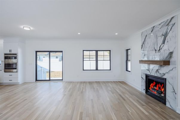 Empty room, Fireplace, Interior, Kitchen, Marble Walls, Recessed Lighting, Stainless Steel Appliances, Wood Texture Flooring