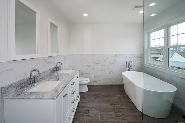 Bathroom, Dual Sink Vanities, Free Standing Baths, Interior, Marble Walls, Recessed Lighting, Wood Texture Flooring