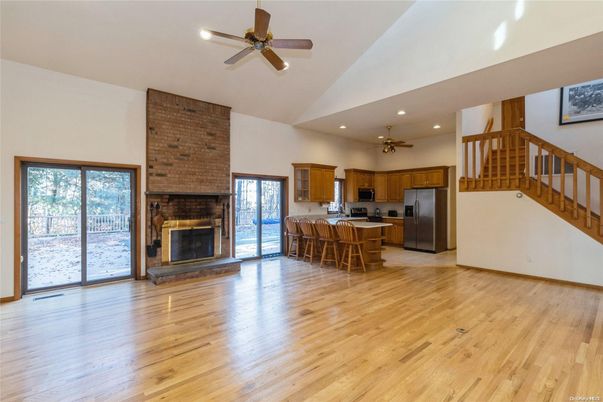 Empty room, Fireplace, Interior, Kitchen, Recessed Lighting, Stainless Steel Appliances, Stone Walls, Wood Texture Flooring