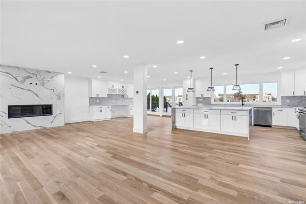 Fireplace, Interior, Kitchen, Marble Walls, Pendant Lights, Recessed Lighting, Stainless Steel Appliances, Wood Texture Flooring