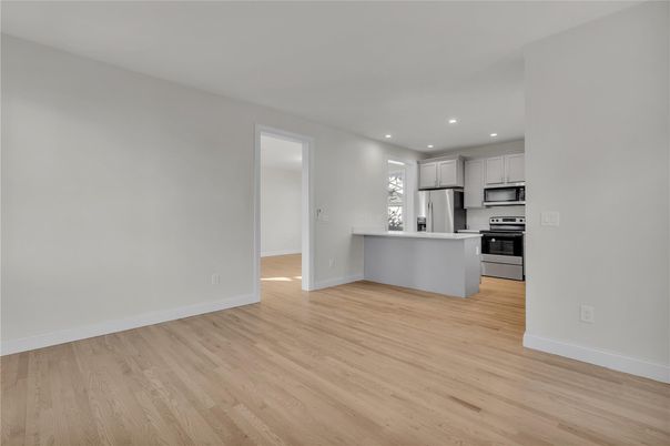 Empty room, Interior, Kitchen, Recessed Lighting, Stainless Steel Appliances, Wood Texture Flooring