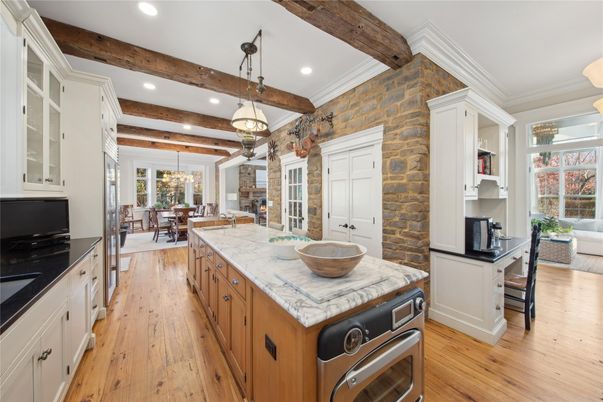 Chandelier, Dining room, Interior, Kitchen, Living room, Pendant Lights, Recessed Lighting, Stainless Steel Appliances, Stone Walls, Wooden Beams, Wood Texture Flooring