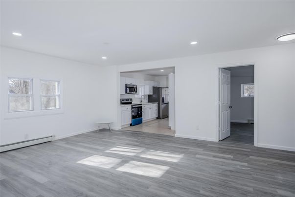 Empty room, Interior, Kitchen, Recessed Lighting, Stainless Steel Appliances, Wood Texture Flooring
