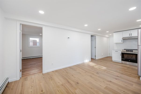 Empty room, Interior, Kitchen, Recessed Lighting, Stainless Steel Appliances, Wood Texture Flooring