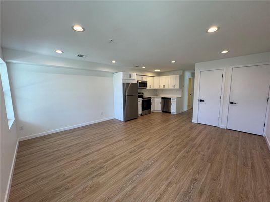 Empty room, Interior, Kitchen, Recessed Lighting, Stainless Steel Appliances, Wood Texture Flooring