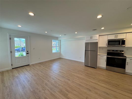 Empty room, Interior, Kitchen, Recessed Lighting, Stainless Steel Appliances, Wood Texture Flooring