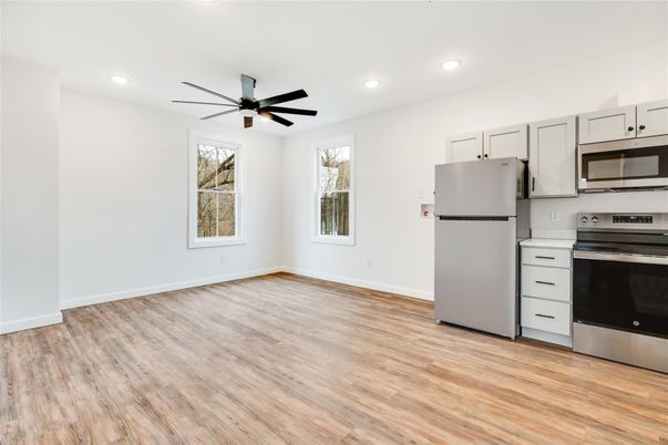 Empty room, Interior, Kitchen, Recessed Lighting, Stainless Steel Appliances, Wood Texture Flooring