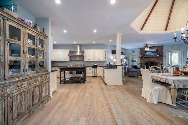 Chandelier, Dining room, Fireplace, Interior, Kitchen, Living room, Pendant Lights, Recessed Lighting, Stainless Steel Appliances, Stone Walls, Wood Texture Flooring