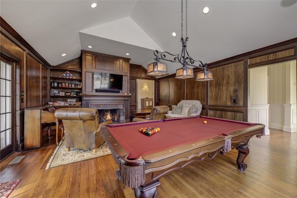 Billiard Table, Chandelier, Fireplace, Game Room, Interior, Pendant Lights, Recessed Lighting, Wood Texture Flooring, Wooden Walls