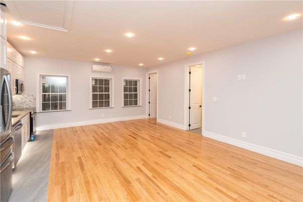 Empty room, Interior, Kitchen, Recessed Lighting, Stainless Steel Appliances, Wood Texture Flooring