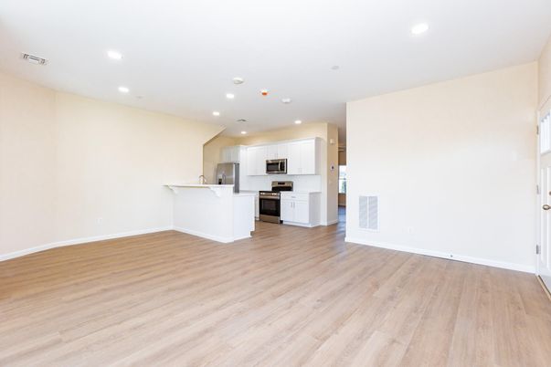 Empty room, Interior, Kitchen, Recessed Lighting, Stainless Steel Appliances, Wood Texture Flooring