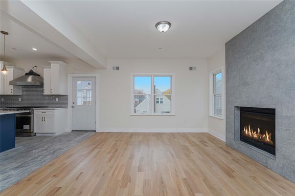 Empty room, Fireplace, Interior, Kitchen, Pendant Lights, Recessed Lighting, Stainless Steel Appliances, Wood Texture Flooring