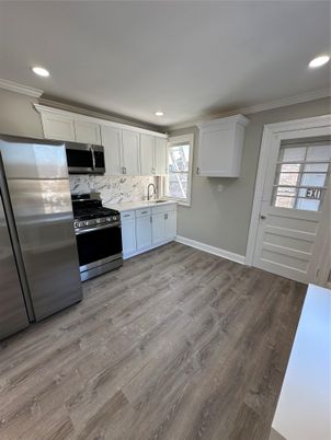 Interior, Kitchen, Marble Walls, Recessed Lighting, Stainless Steel Appliances, Wood Texture Flooring