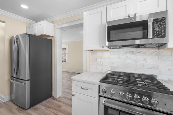 Interior, Kitchen, Marble Walls, Recessed Lighting, Stainless Steel Appliances, Wood Texture Flooring