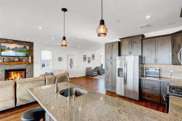 Fireplace, Interior, Kitchen, Living room, Pendant Lights, Recessed Lighting, Stainless Steel Appliances, Stone Walls, Wood Texture Flooring