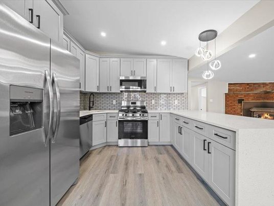 Fireplace, Interior, Kitchen, Pendant Lights, Recessed Lighting, Stainless Steel Appliances, Stone Walls, Wood Texture Flooring