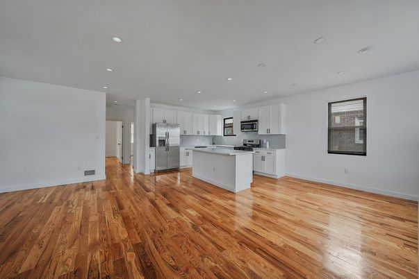Empty room, Interior, Kitchen, Recessed Lighting, Stainless Steel Appliances, Wood Texture Flooring