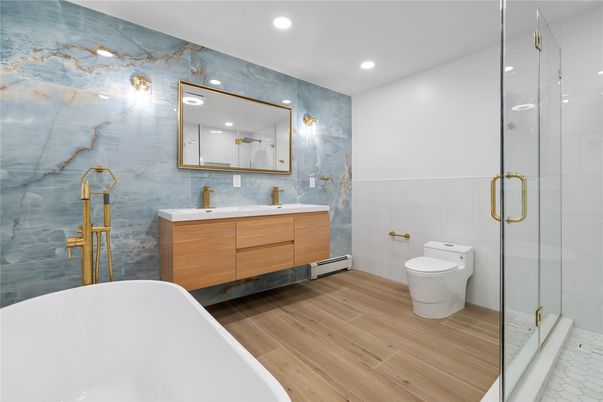 Bathroom, Dual Sink Vanities, Free Standing Baths, Glass Shower, Interior, Marble Walls, Recessed Lighting, Wood Texture Flooring