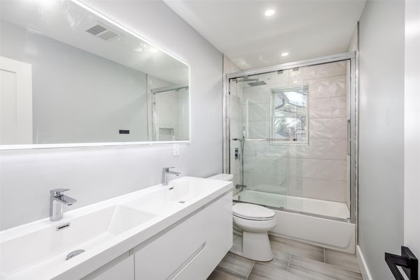 Bathroom, Dual Sink Vanities, Glass Shower, Interior, Marble Walls, Recessed Lighting, Wood Texture Flooring