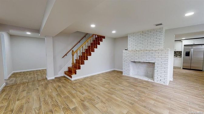 Empty room, Fireplace, Interior, Kitchen, Recessed Lighting, Stainless Steel Appliances, Stone Walls, Wood Texture Flooring