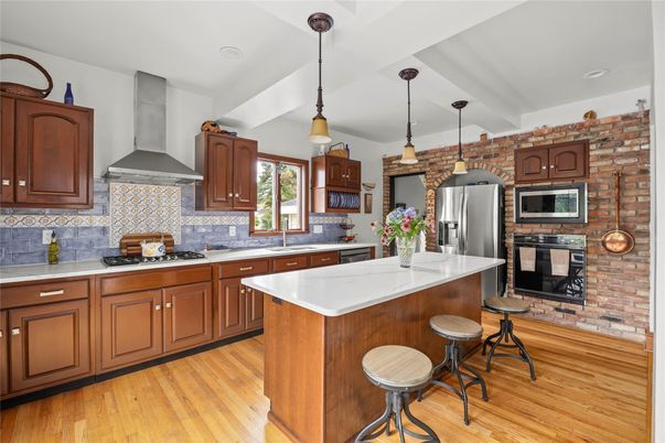 Fireplace, Interior, Kitchen, Pendant Lights, Recessed Lighting, Stainless Steel Appliances, Stone Walls, Wood Texture Flooring