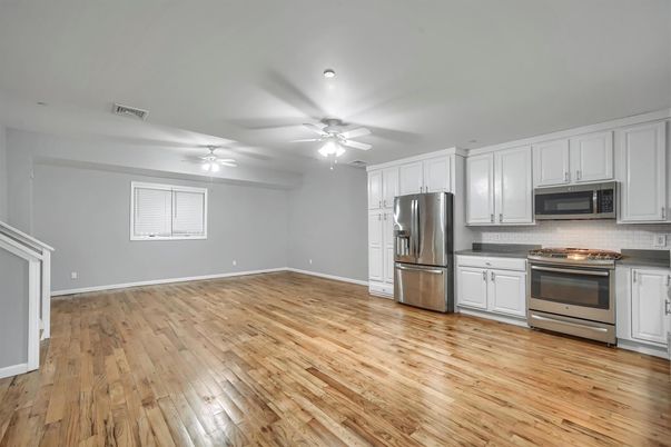 Empty room, Interior, Kitchen, Recessed Lighting, Stainless Steel Appliances, Wood Texture Flooring