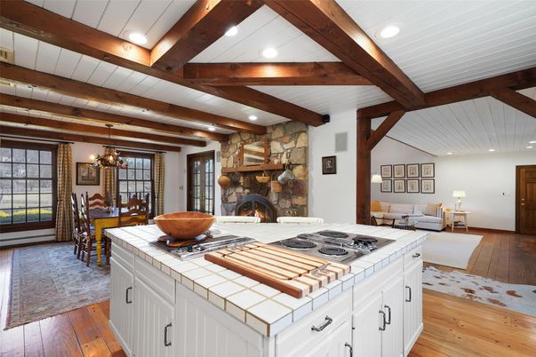 Chandelier, Dining room, Fireplace, Interior, Kitchen, Living room, Recessed Lighting, Stone Walls, Tile Countertops, Wooden Beams, Wood Texture Flooring