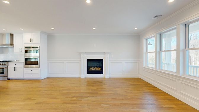 Empty room, Fireplace, Interior, Kitchen, Recessed Lighting, Stainless Steel Appliances, Wood Texture Flooring
