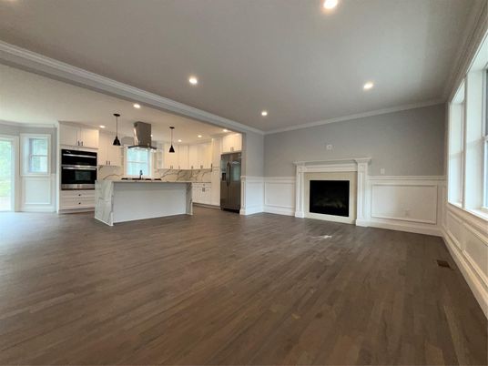 Empty room, Fireplace, Interior, Kitchen, Pendant Lights, Recessed Lighting, Stainless Steel Appliances, Wood Texture Flooring