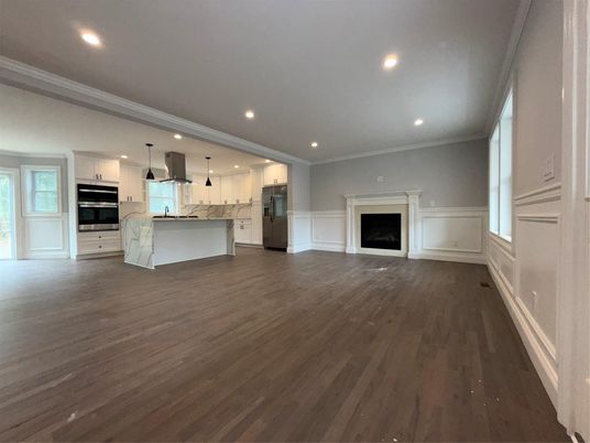 Empty room, Fireplace, Interior, Kitchen, Recessed Lighting, Stainless Steel Appliances, Wood Texture Flooring
