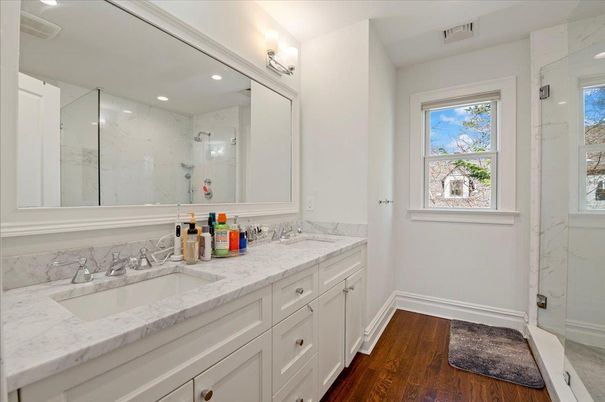 Bathroom, Dual Sink Vanities, Glass Shower, Interior, Marble Walls, Recessed Lighting, Wood Texture Flooring