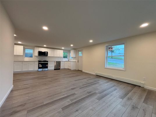 Empty room, Interior, Kitchen, Recessed Lighting, Stainless Steel Appliances, Wood Texture Flooring