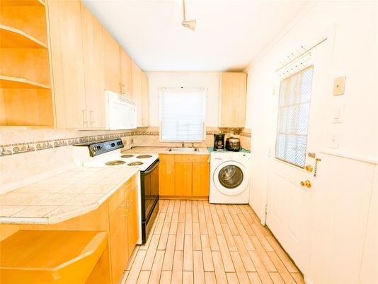Interior, Kitchen, Tile Countertops, Washer, Wood Texture Flooring