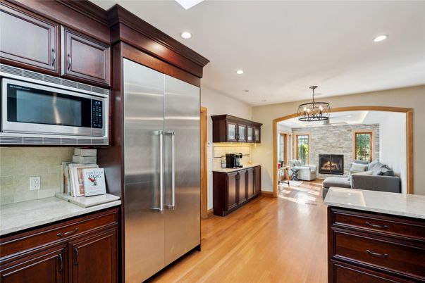 Chandelier, Fireplace, Interior, Kitchen, Living room, Pendant Lights, Recessed Lighting, Stainless Steel Appliances, Wood Texture Flooring