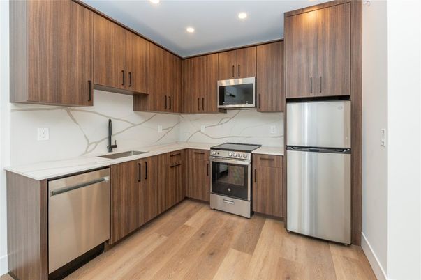 Interior, Kitchen, Marble Walls, Recessed Lighting, Stainless Steel Appliances, Wood Texture Flooring
