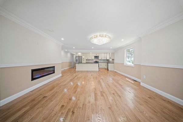 Chandelier, Empty room, Fireplace, Interior, Kitchen, Recessed Lighting, Stainless Steel Appliances, Wood Texture Flooring
