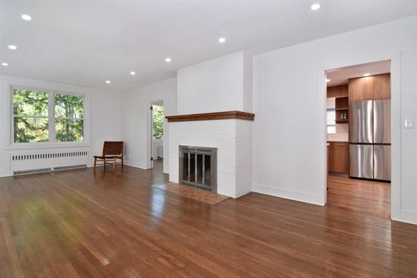 Empty room, Fireplace, Interior, Kitchen, Recessed Lighting, Stainless Steel Appliances, Wood Texture Flooring