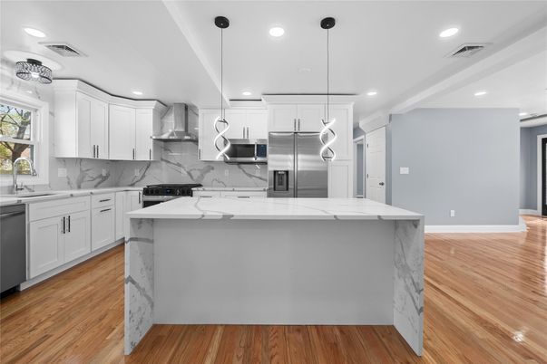 Interior, Kitchen, Marble Walls, Pendant Lights, Recessed Lighting, Stainless Steel Appliances, Wood Texture Flooring