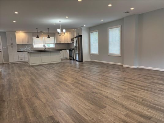 Empty room, Interior, Kitchen, Pendant Lights, Recessed Lighting, Stainless Steel Appliances, Wood Texture Flooring