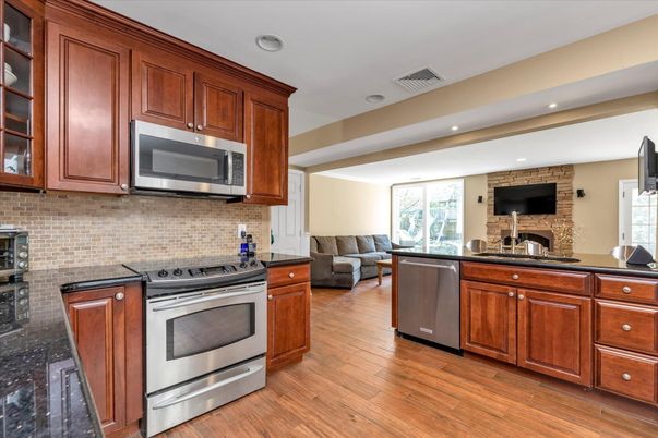 Fireplace, Interior, Kitchen, Recessed Lighting, Stainless Steel Appliances, Stone Walls, Wood Texture Flooring