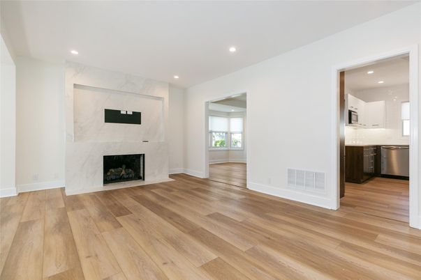 Empty room, Fireplace, Interior, Kitchen, Marble Walls, Recessed Lighting, Stainless Steel Appliances, Wood Texture Flooring
