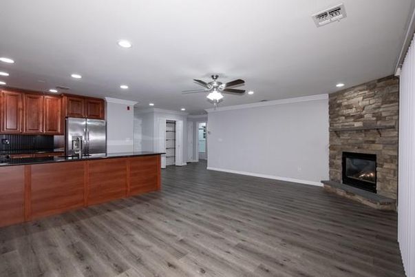 Empty room, Fireplace, Interior, Kitchen, Recessed Lighting, Stainless Steel Appliances, Stone Walls, Wood Texture Flooring